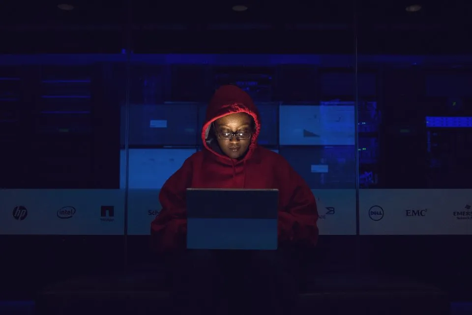 Person working on a laptop at night in a dark room