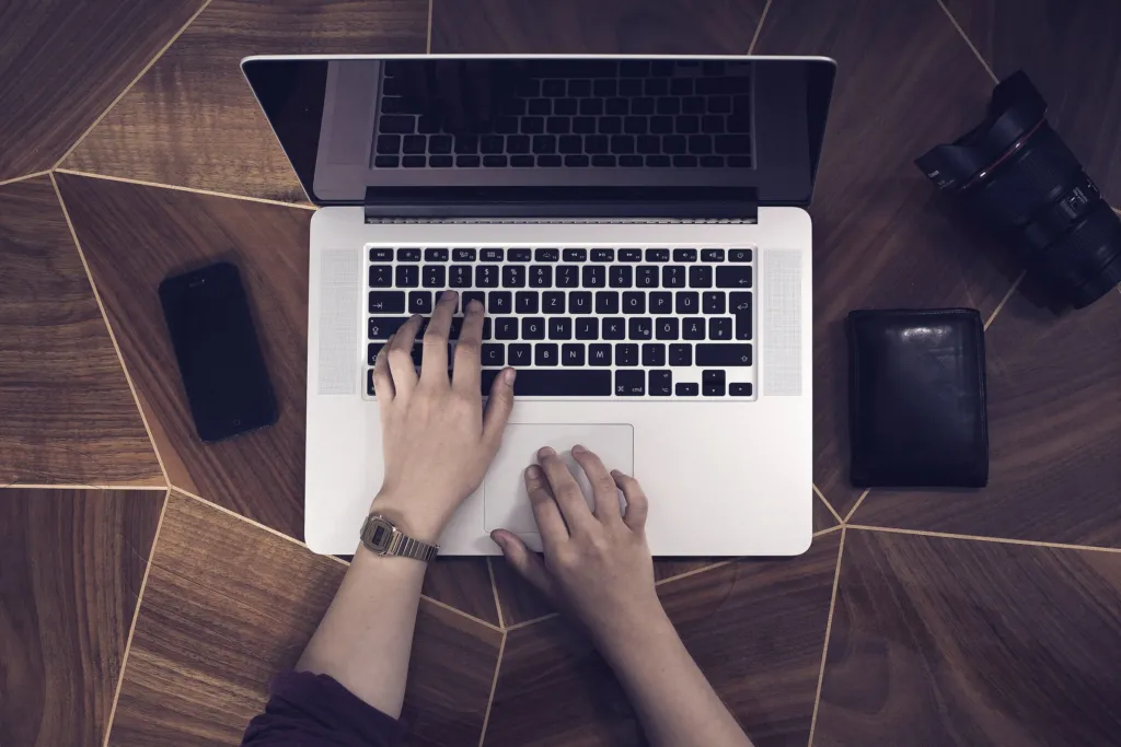 Hands typing on a laptop keyboard